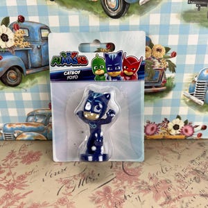 May include: A Catboy YoYo toy from the PJ Masks series, packaged in a clear plastic blister pack. The Catboy figure is blue with white spots and a mask. The packaging features the PJ Masks logo and other characters.