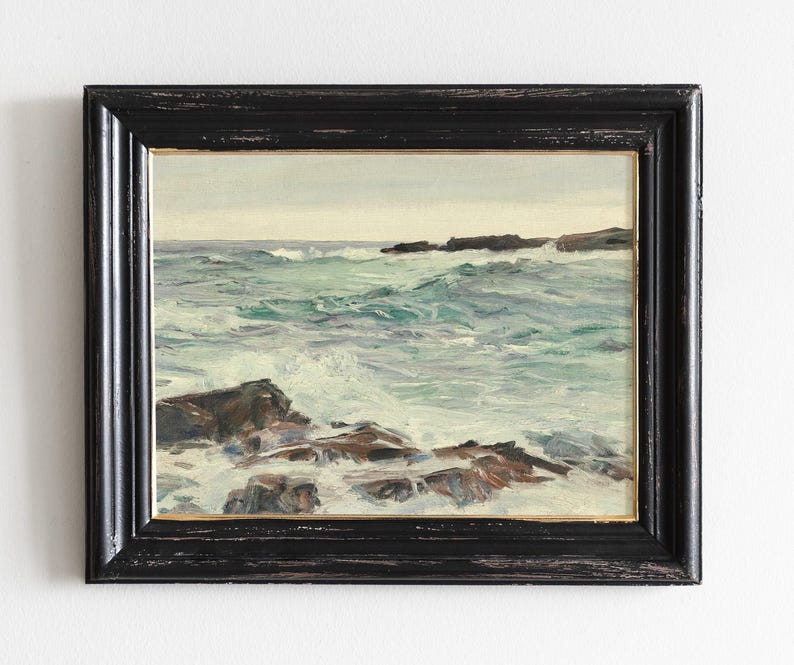 The image is a framed painting depicting a rocky coastline with crashing waves.