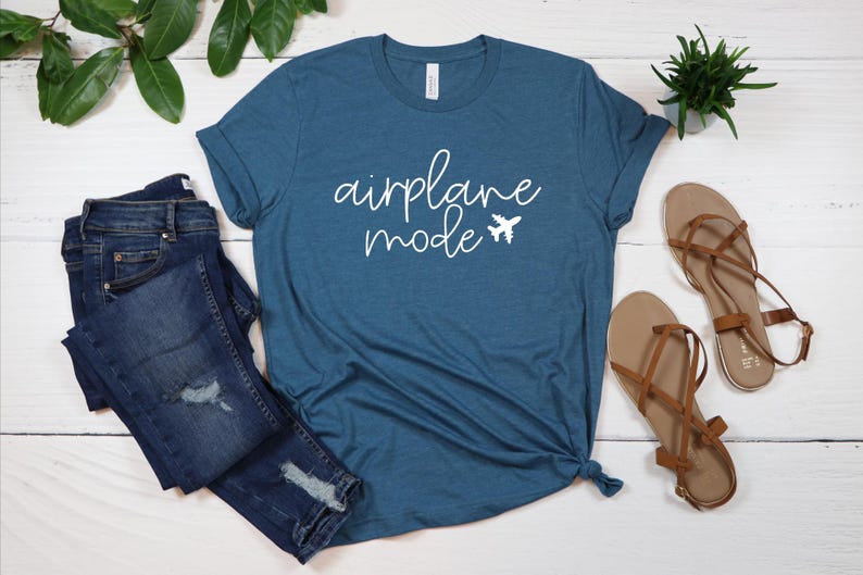 May include: A teal blue t-shirt with the text "airplane mode" in white cursive lettering and a small airplane icon.