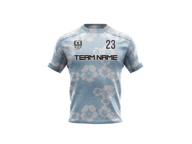 May include: A light blue soccer jersey with a white floral pattern. The jersey has a black team logo, the text "TEAM NAME", and the number "23" printed on the front.