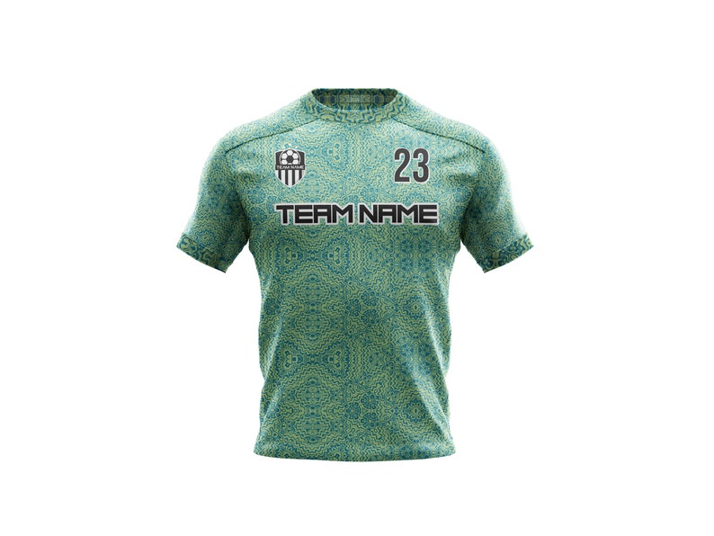 May include: Green and yellow soccer jersey with a black team logo, the text "TEAM NAME" and the number "23".