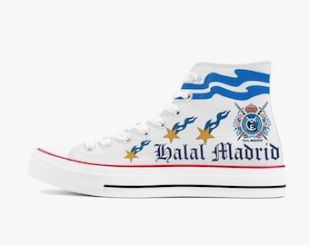 Puede incluir: Zapatillas blancas de lona de caña alta con un diseño de olas azul y blanco, cinco estrellas doradas y el texto "Halal Madrid" en negro. El escudo del Real Madrid también aparece en la zapatilla.