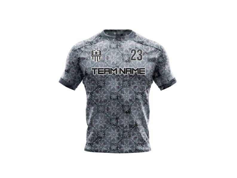 May include: Gray soccer jersey with a white and black snowflake pattern. The jersey has a team logo on the left chest and the number 23 on the right chest. The text "TEAM NAME" is printed below the logo.