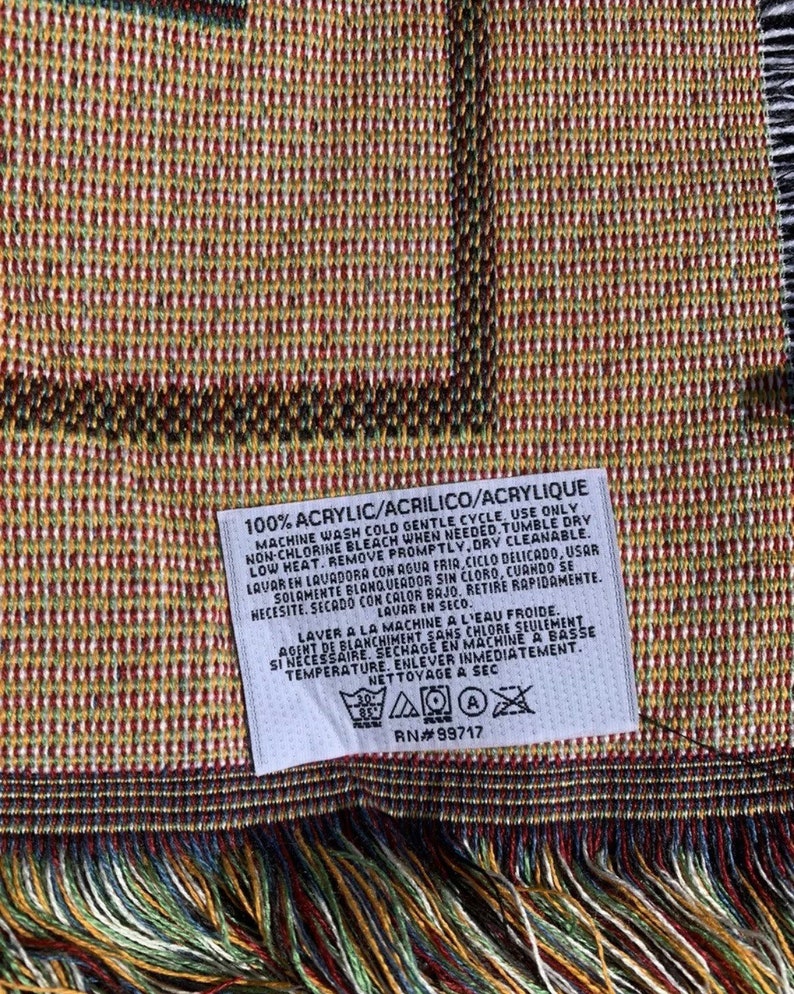Puede incluir: Una etiqueta blanca con texto negro que detalla las instrucciones de cuidado para una manta de 100% acr&iacute;lico. La etiqueta incluye instrucciones de lavado y secado a m&aacute;quina, as&iacute; como instrucciones de limpieza en seco. La etiqueta tambi&eacute;n incluye un cuadro de s&iacute;mbolos de cuidado con iconos para lavado a m&aacute;quina, blanqueador, secado a m&aacute;quina y limpieza en seco.