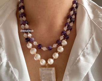 May include: A layered necklace with white pearls, amethyst, and moonstone beads. The necklace has a square selenite pendant.