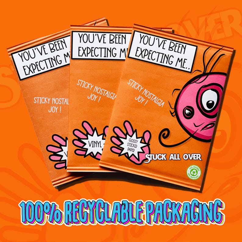 May include: Three orange packages with the text "You've Been Expecting Me."  The packages have a cartoon hand with the text "Sticky Nostalgia Joy!" and "Vinyl" or "Glossy Stickered Paper". The packages are on a bright orange background with the text "Stuck All Over" and "100% Recyclable Packaging".