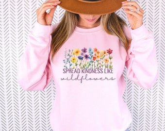 May include: Pink sweatshirt featuring a watercolour design of colourful wildflowers and the text "Spread Kindness Like Wildflowers".