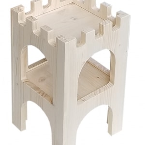 Puede incluir: Un taburete de madera con forma de castillo con dos estantes. El taburete est&aacute; hecho de madera sin tratar y tiene un color natural.