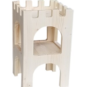 Puede incluir: Un taburete de madera con forma de castillo con dos estantes y un dise&ntilde;o de corte. El taburete est&aacute; hecho de madera sin terminar y tiene un color natural.