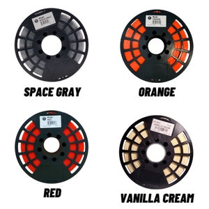 May include: Four spools of PLA+ filament in Space Gray, Orange, Red, and Vanilla Cream. Each spool is wound on a black reel with the color name printed in bold, black text below.