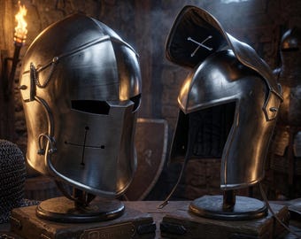 May include: Two polished steel knight helmets displayed on wooden stands. The left helmet features a cross-shaped visor slit and a small chain detail. The right helmet has an open visor with a white cross emblem on the interior lining.