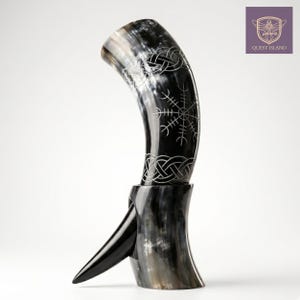May include: A black and white horn drinking vessel with a decorative stand. The horn features etched Celtic knot and rune designs. The Quest Island logo is in the upper right corner.