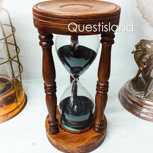 May include: A wooden hourglass with black sand, featuring a dark wood base and pillars. The hourglass is approximately 10 inches tall.