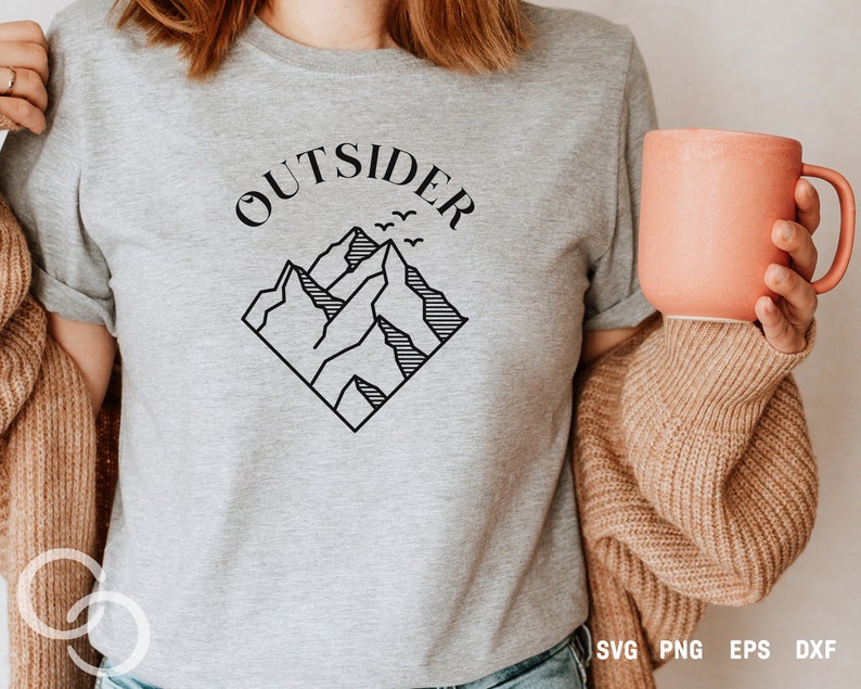 May include: A gray t-shirt with the text "OUTSIDER" in black lettering above a black line drawing of mountains with birds flying over them.
