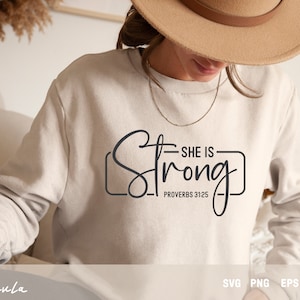 May include: A white sweatshirt with the text "She is Strong - Proverbs 31:25" in black lettering.