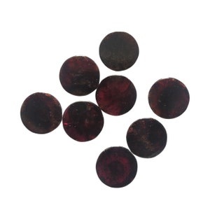 Peut inclure: Huit cabochons ronds de pierres précieuses rouge foncé avec un léger éclat métallique.