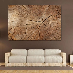 May include: A close-up of a tree trunk cross-section, showing the intricate pattern of rings and cracks in the wood. The wood is a warm brown color with a natural, rustic texture.