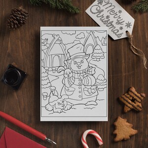 May include: A black and white coloring page featuring a snowman with a hat and scarf holding a bunny rabbit. A dog is sitting in front of the snowman. The page is surrounded by a wooden background with Christmas decorations.