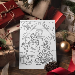 May include: A black and white coloring page featuring a gnome standing in front of a house with a Christmas tree. The gnome is holding a gift box and is smiling. The house has a chimney and a window. The Christmas tree is decorated with ornaments and stars.
