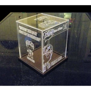 May include: A clear acrylic display case with a black base, featuring a pop figure inside. The case has a printed design on the sides, including the words "I'm not talking about power, I was the power" and "Pop!" with a speech bubble.