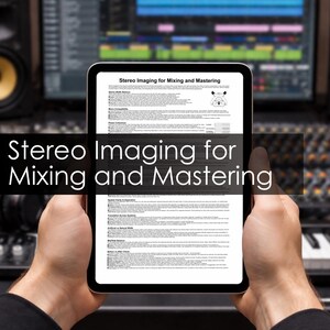 May include: A tablet displaying a document titled "Stereo Imaging for Mixing and Mastering" is held in front of a sound mixing console. The text is in black on a white background. The background includes studio equipment.