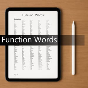 May include: A black tablet displays a list of "Function Words" with contractions and other words. A white stylus rests on a wooden surface next to the tablet. The text "Function Words" is displayed in a black banner across the tablet.