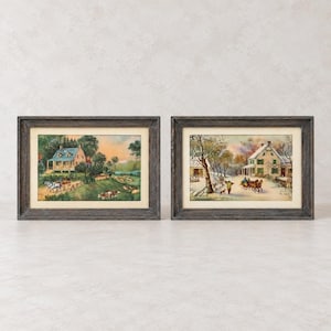 May include: Two rectangular framed prints featuring pastoral scenes. The left print shows a house, trees, and horses in a field. The right print depicts a snow-covered landscape with a house, bare trees, and a horse-drawn carriage. Both have dark wood frames.