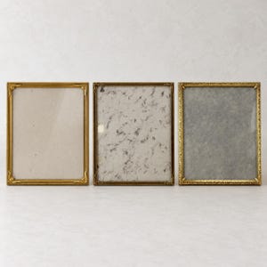 May include: Three rectangular picture frames with metallic gold finishes. The left frame has smooth edges with decorative corner accents. The middle frame features a textured surface. The right frame has an intricate, repeating pattern.