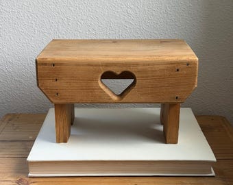 Taburete de madera rústico vintage con forma de corazón calado y soporte para plantas estilo granja de mediados de siglo.