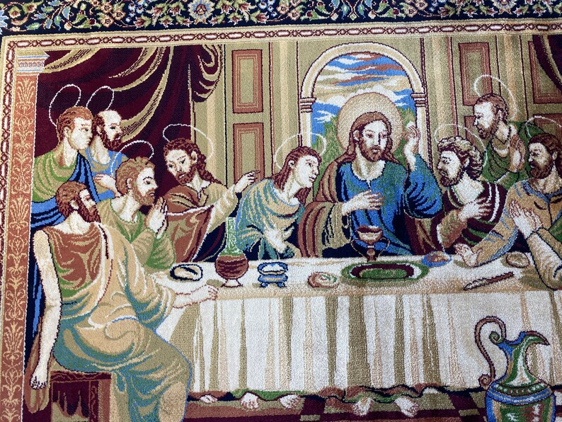 Może przedstawiać: Gobelin przedstawiający Ostatnią Wieczerzę, z Jezusem Chrystusem i jego uczniami zebranymi wok&oacute;ł stołu. Scena rozgrywa się w pokoju z oknem wychodzącym na krajobraz. Gobelin jest wykonany z tkanego materiału z misternymi detalami.