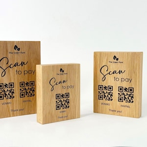 Könnte beinhalten: Drei Holzblöcke mit dem Text "Scan to pay" und QR-Codes für Venmo und PayPal. Die Blöcke sind hellbraun mit dem Logo "The Green Fork" oben und den Worten "Thank you!" unten.