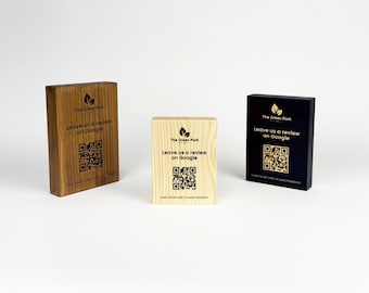 May include: Three wooden blocks with the text "The Green Fork, Leave us a review on Google" and a QR code. The blocks are in shades of brown, natural wood, and black. The blocks are rectangular and stand upright.