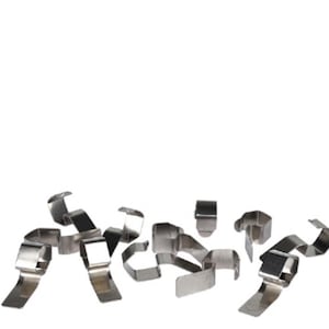 May include: A group of silver metal clips, scattered on a white background. The clips are designed to hold items together, such as papers or fabric.