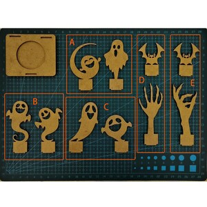 May include: A collection of laser-cut wooden Halloween decorations, including ghosts, bats, and spooky hands. The pieces are arranged on a grid cutting mat, ready for assembly or painting. The designs are perfect for DIY Halloween crafts.