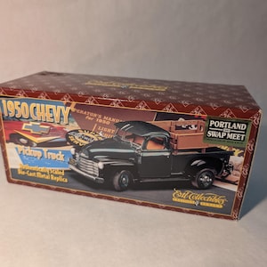 May include: A white ceramic mug with a black handle and the text "But First, Coffee" in a bold, black font. The mug is set against a blurred background, highlighting its simple design.