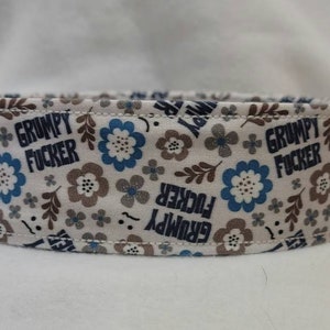 Könnte beinhalten: Weißer Stoff mit einem blauen und braunen Blumenmuster. Der Stoff hat den Text "Grumpy Fucker" wiederholt über die gesamte Fläche.