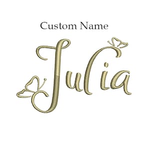 May include: A gold embroidered design of the name "Julia" with butterfly accents. The text "Custom Name" is above the name.