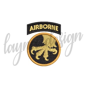 Może przedstawiać: Naszywka haftowana w kolorze czarnym i złotym z napisem "AIRBORNE" złotymi literami i wzorem złotej szpony orła.