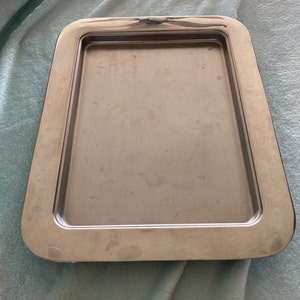 May include: A silver serving tray with a raised rim and a smooth, reflective surface.