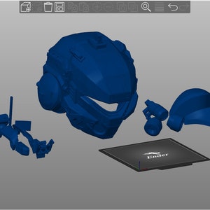 Peut inclure: Ensemble de pi&egrave;ces bleues imprim&eacute;es en 3D, comprenant un casque et divers composants, ainsi qu'une base rectangulaire avec le mot "Ender" imprim&eacute;. Les pi&egrave;ces sont dispos&eacute;es sur une surface grise.