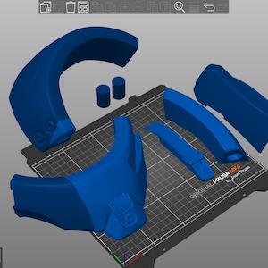Może przedstawiać: Tr&oacute;jwymiarowy model hełmu wydrukowany na niebieskiej drukarce 3D Original Prusa MK4. Hełm składa się z kilku części, w tym dużego zakrzywionego elementu, dw&oacute;ch mniejszych zakrzywionych element&oacute;w i dw&oacute;ch cylindrycznych element&oacute;w.