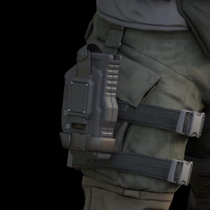May include: A black tactical leg holster with a strap and buckle. The holster is attached to a pair of dark green pants.