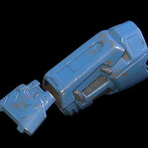 May include: A blue robotic arm with a worn, weathered finish. The arm is segmented and has a series of buttons and controls. The arm is detached at the elbow and the two pieces are lying side by side.