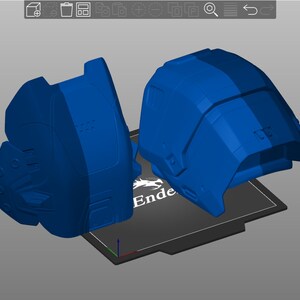 May include: Two blue 3D printed objects on a black print bed with the word "Ender" printed on it.