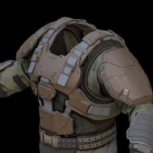 May include: A tan and gray tactical vest with shoulder pads and a belt. The vest has multiple panels and straps, with a military-style design. The sleeves are olive green. The background is black.