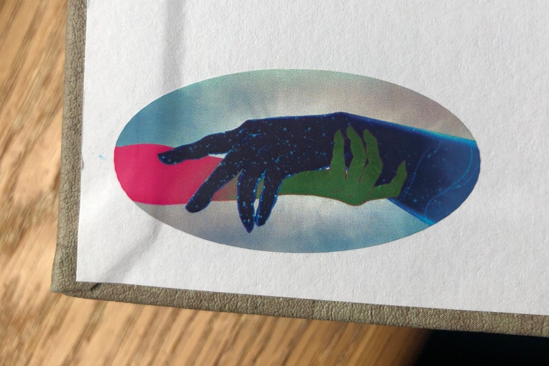 May include: A sticker featuring a blue and green hand reaching out to a black hand with white stars. The hands are set against a blue and pink background.