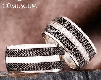 May include: Two silver rings with intricate designs. One ring has a row of small white stones. Both rings have a textured pattern of interlocking circles.