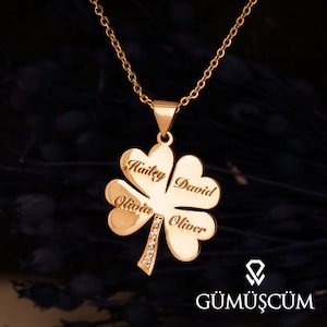 Puede incluir: Collar de trébol de cuatro hojas de oro con los nombres Hailey, David, Olivia y Oliver grabados en cada hoja. El collar tiene una cadena y una fila de pequeñas piedras transparentes en el tallo.