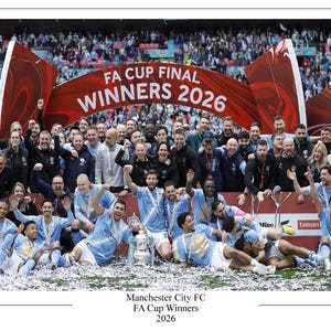 以下が含まれることがあります： 2026年のFAカップ決勝での勝利を祝うサッカーチーム。赤いバナーには「FA CUP FINAL WINNERS 2026」と書かれています。チームは水色のシャツを着ています。銀色の紙吹雪が散らばっています。「Manchester City FC FA Cup Winners 2026」というテキストが含まれています。
