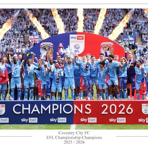 Op de afbeelding: Een team voetballers in lichtblauwe tenues viert op een podium. De woorden "CHAMPIONS 2026" staan erop. De Sky Bet EFL Championship-trofee wordt omhoog gehouden. De achtergrond toont een menigte en vlammen.